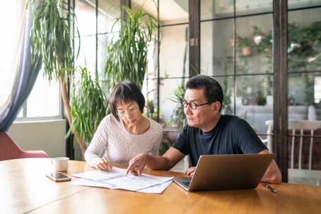 Elderly couple looking at paperwork.